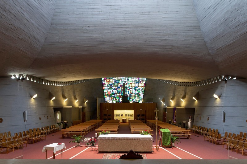 Schatten, Licht und die Farben der Glasfront dienen als Gestaltungselemente im Inneren der Kirche Pius X. in Bozen. (Foto: LPA/Alexa Rainer)