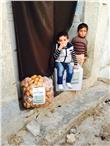 Bambini nella zona di Aleppo con gli aiuti alimentari forniti dall’Ai. Bi. Foto: Ai.Bi.