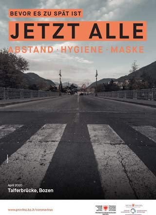 Das Schwarz-Weiß-Foto vom April 2020 zeigt die Talfer-Brücke in Bozen völlig menschenleer. Das Bild wird von dem Slogan begleitet: Bevor es zu spät ist. Jetzt alle: Abstand, Hygiene, Maske.