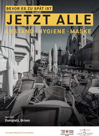 Das Schwarz-Weiß-Foto vom April 2020 zeigt den berühmten Platz vor dem Brixner Dom leblos, auf den Tischen der geschlossenen Lokale ruhen Stühle. Das Bild wird von dem Slogan begleitet: Bevor es zu spät ist. Jetzt alle: Abstand, Hygiene, Maske. 