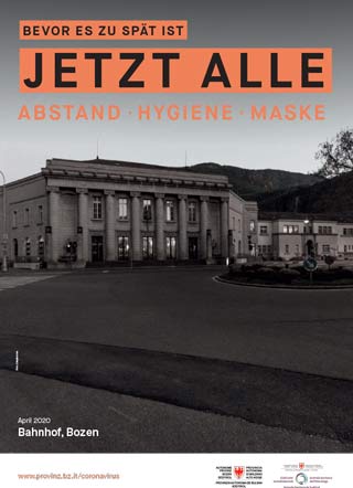 Aufgenommen im April 2020, zeigt das Schwarz-Weiß-Foto einen ungewöhnlichen Bozner Bahnhofsplatz ohne Verkehr und ohne Menschen. Das Bild wird von dem Slogan begleitet: Bevor es zu spät ist. Jetzt alle: Abstand, Hygiene, Maske. 